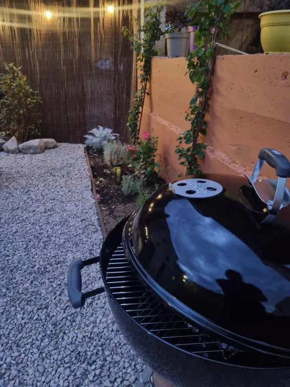 Charcoal barbecue on the patio, lit at night under the string lights