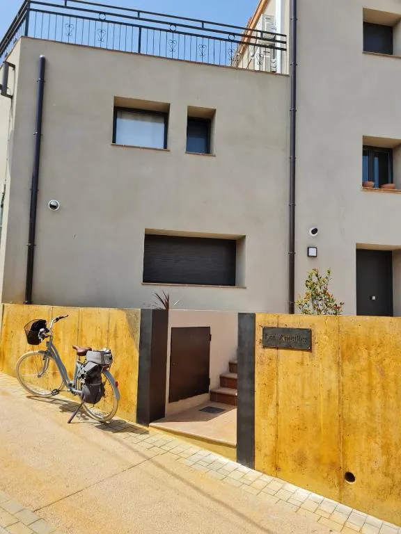 The front of Les Ametlles on the street in Masarac, with the Corten steel wall and a bicycle leaning against it