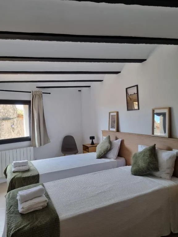 Bedroom with two single beds, olive-green textiles and a window onto the street