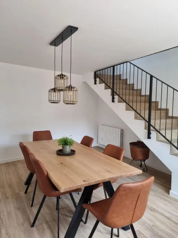 Dining room with the large wooden table and the black steel staircase up to the floor above