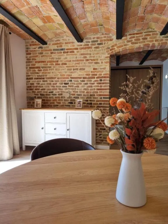 Dining room under the original tiled vault, with a wall of stone and old brick