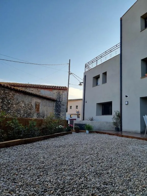 Gravel patio with the neighbouring house’s dry-stone wall at dusk