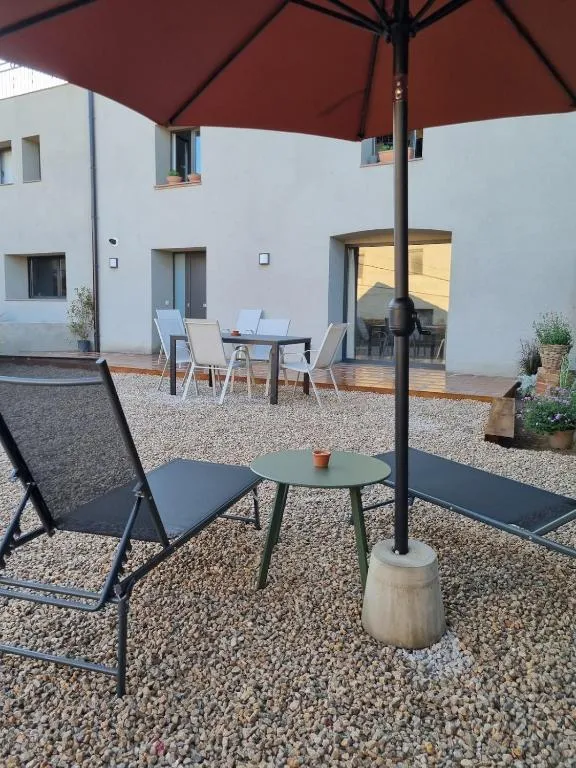 The private patio at Les Ametlles, with the parasol open, the outdoor dining table and the front of the house in the background