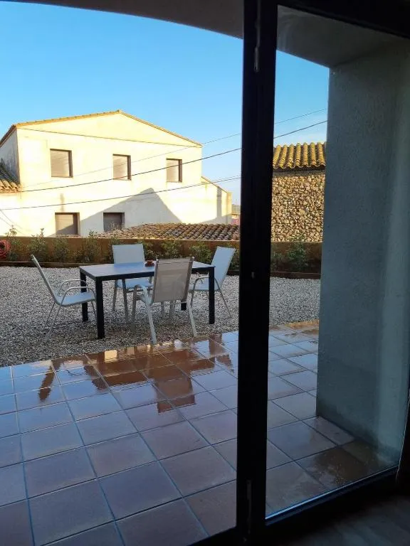 The patio seen from inside the house through the glass door, with the table laid