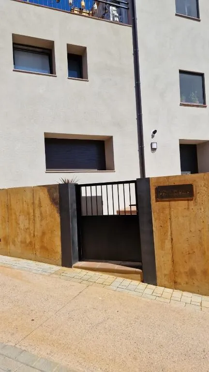 Entrance gate of Corten steel and black railing, seen from the street